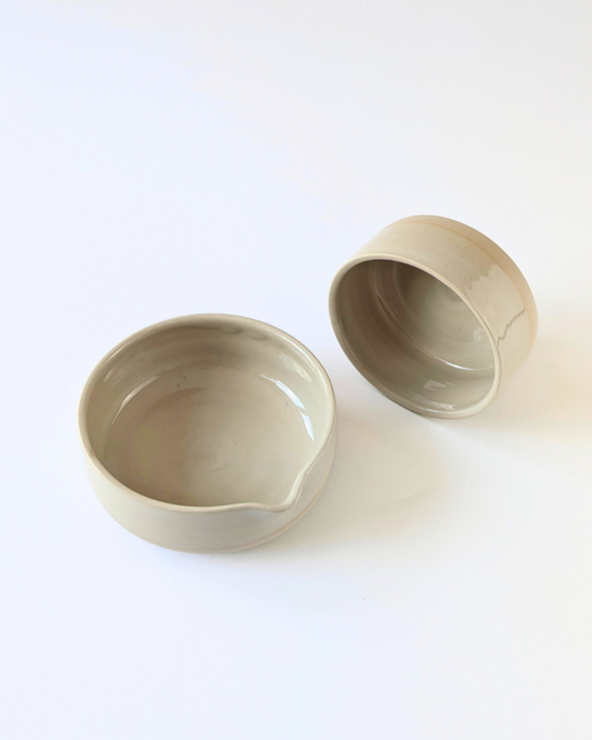 Two beige ceramic bowls on a white background