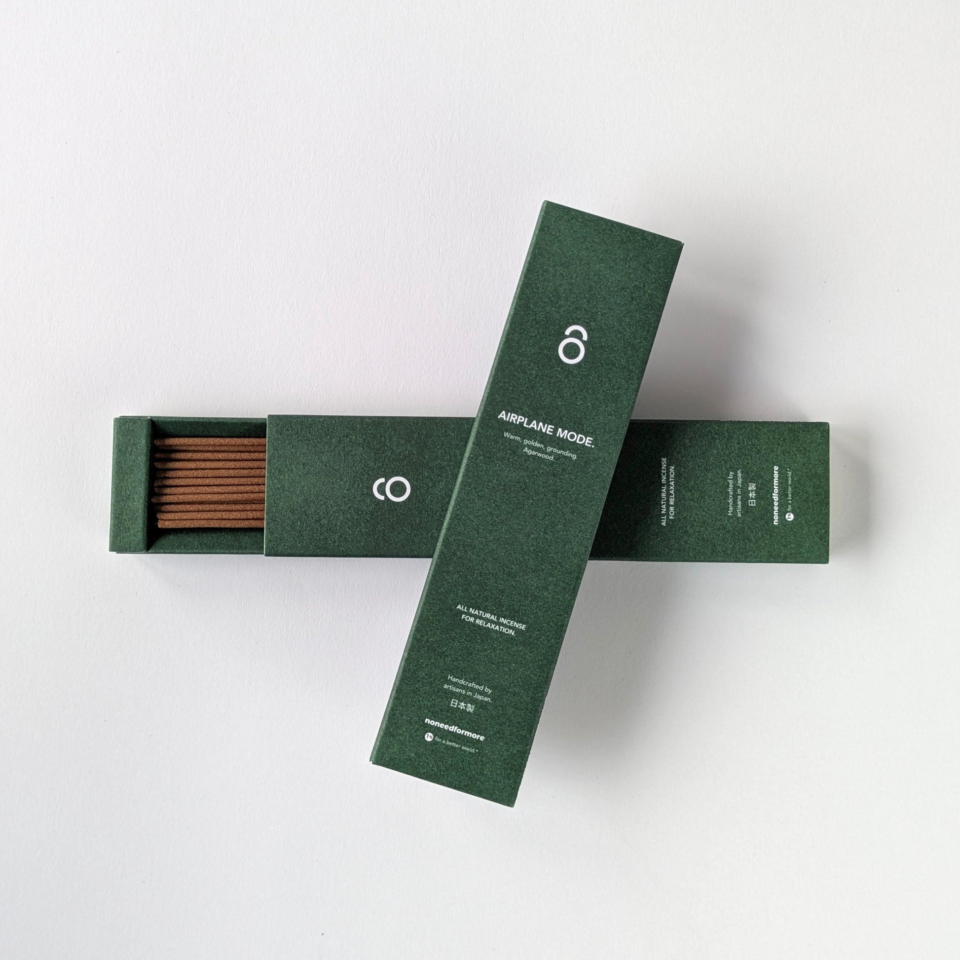 Two green boxes with incense sticks on a white background
