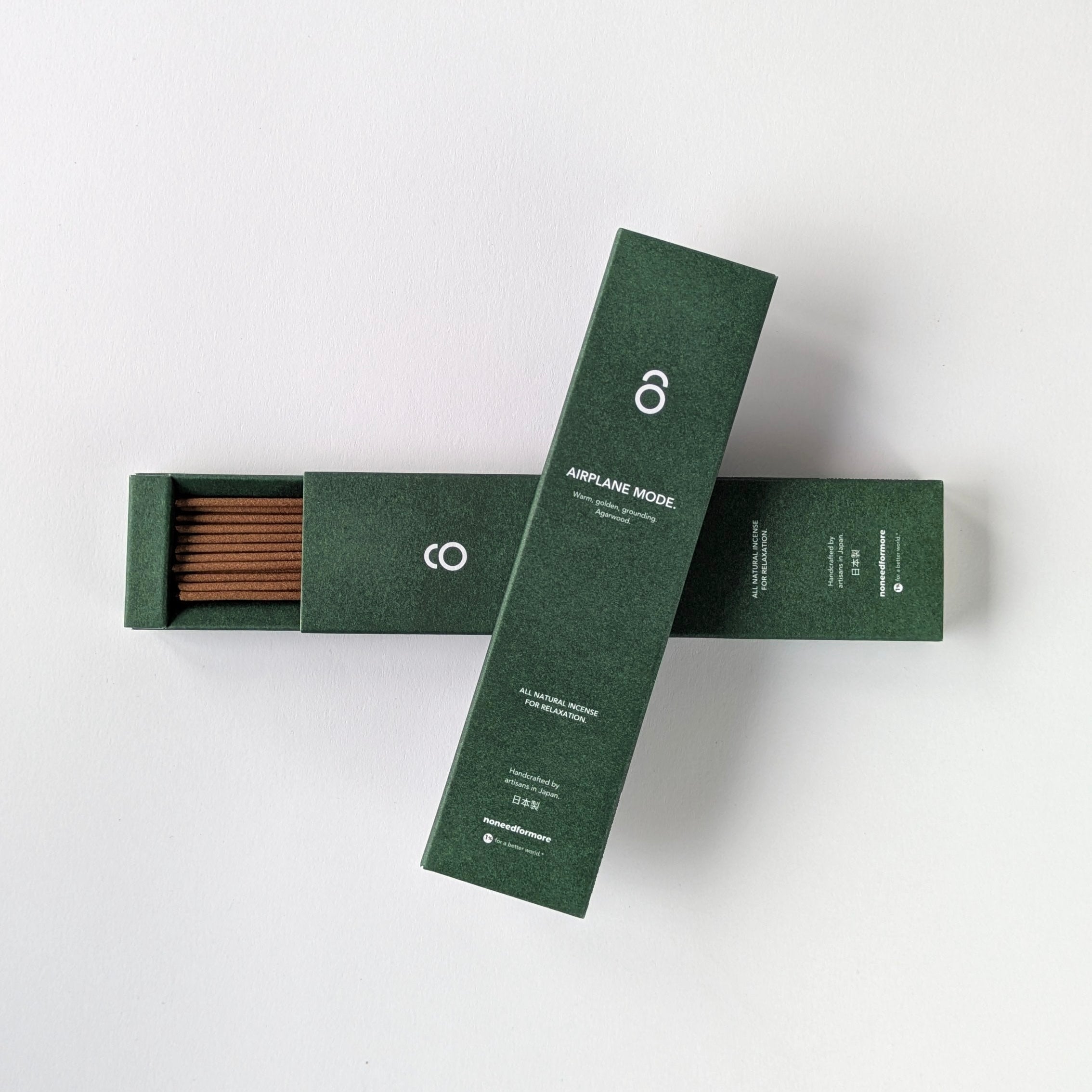 Two green boxes with incense sticks on a white background