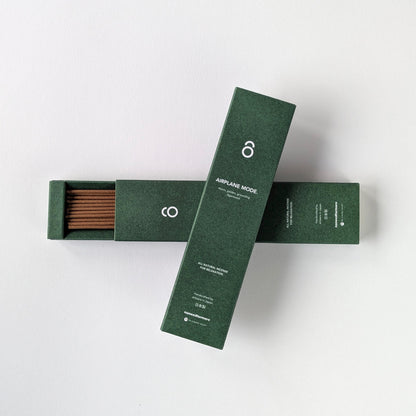 Two green boxes with incense sticks on a white background